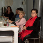 Zdjęcie przedstawia kobiety siedzace przy stole.