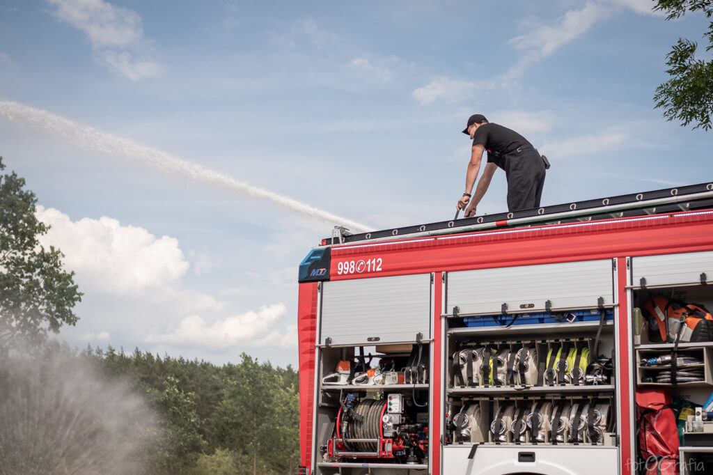 Zdjęcie przedstawia strażaka na wozie.